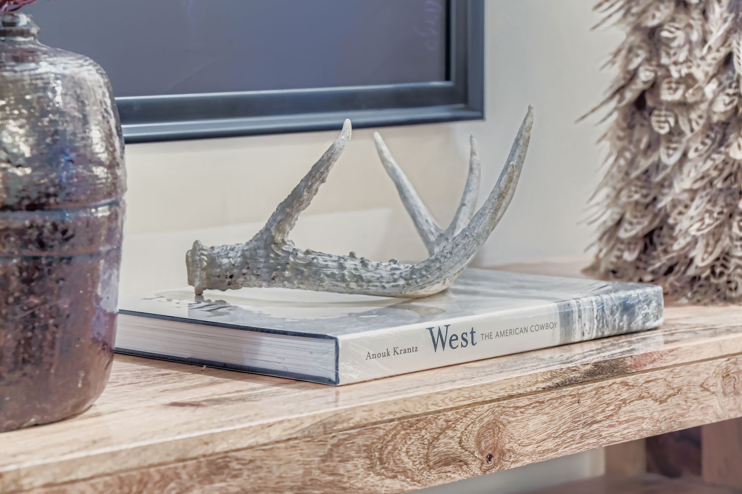 You'll love the thoughtful details in your living space—rustic antlers and curated books create a cozy, welcoming atmosphere.