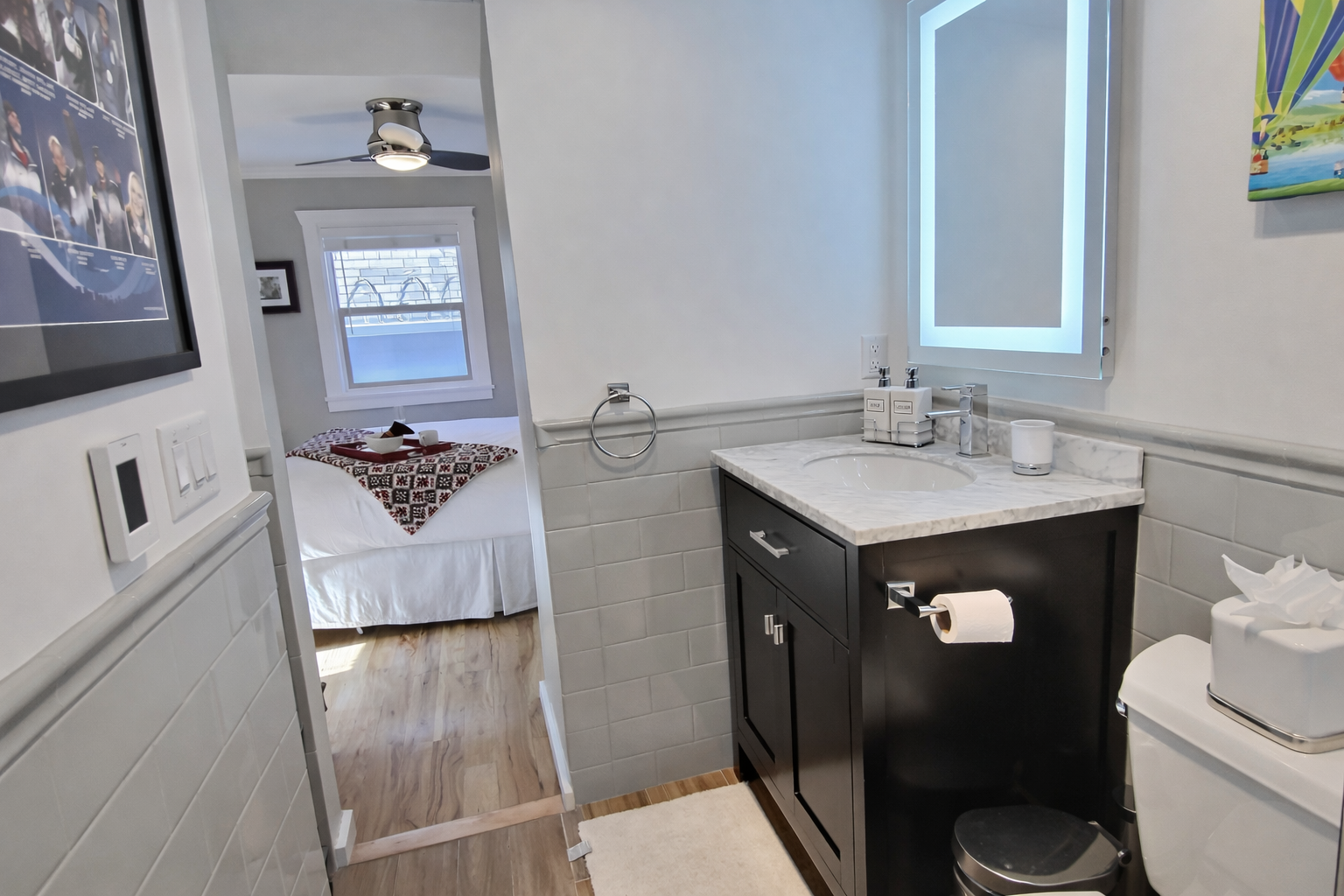 Step into the sleek, modern bathroom with a single vanity and a large, illuminated mirror. A functional and stylish space for your stay in Park City.