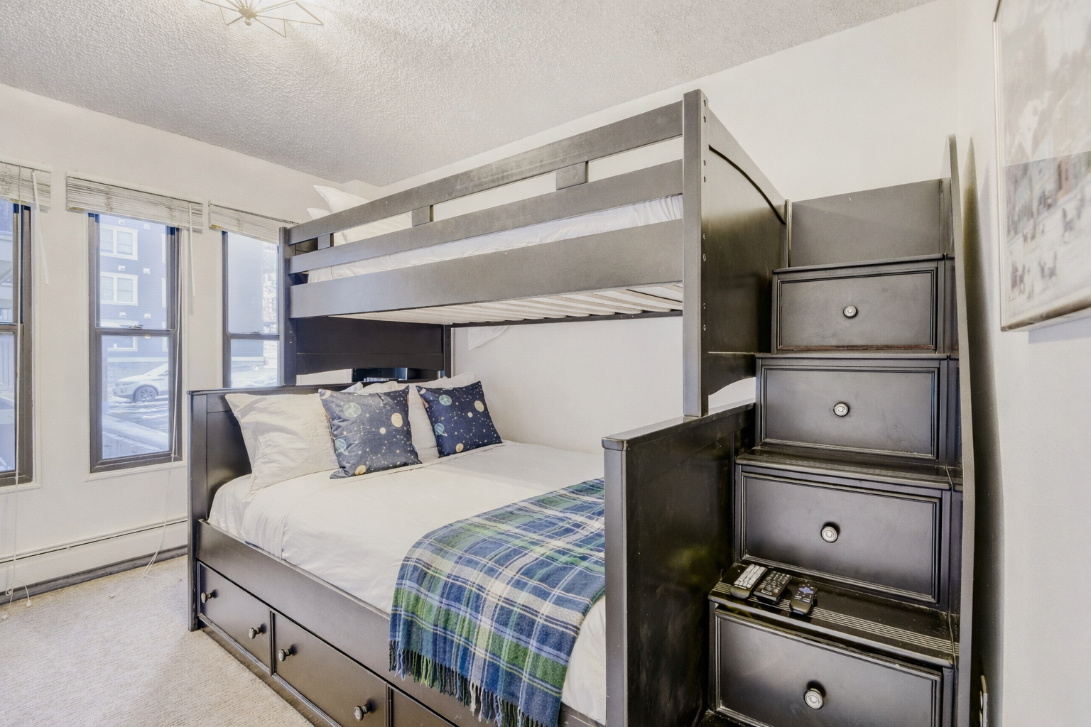 Sleep peacefully in this clever bunk bed setup with built-in storage stairs and cozy blue accents that maximize your space beautifully.