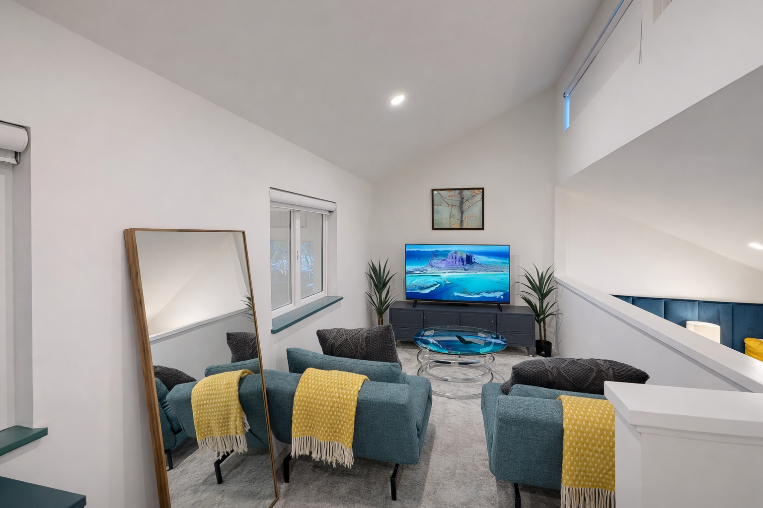 Sink into plush teal armchairs with cozy yellow throws while enjoying your favorite shows on the large smart TV.