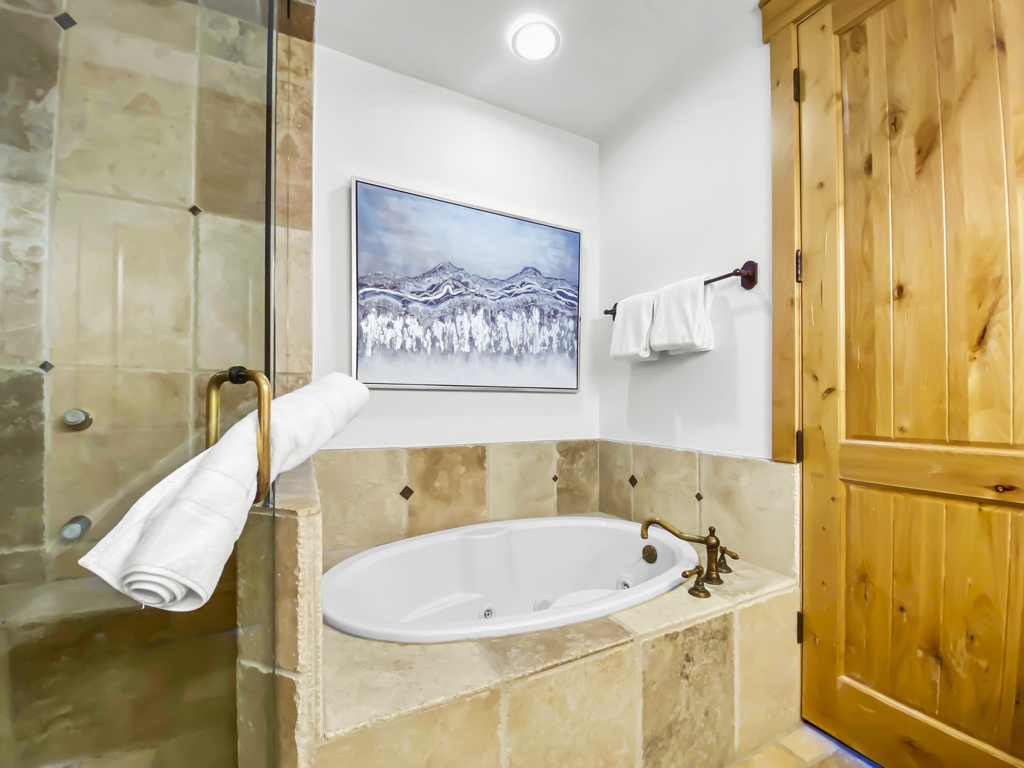 Unwind in your private bathroom featuring a luxurious soaking tub, walk-in shower, and plush towels—your perfect retreat after a day of adventure.