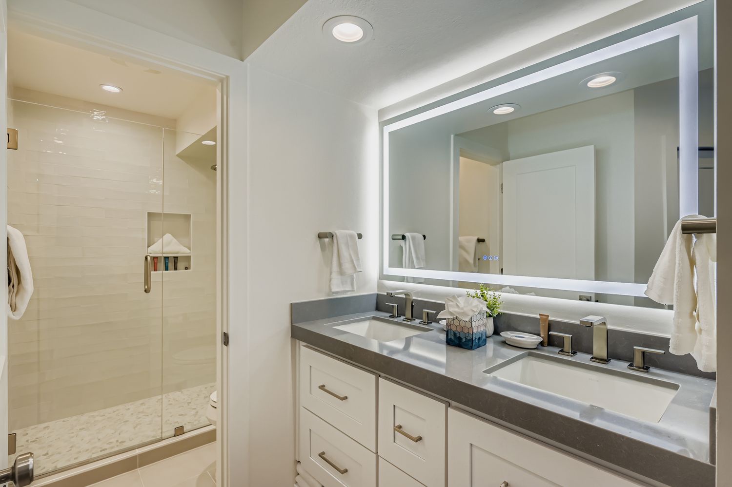 Your spacious bathroom features dual vanities, a glass-enclosed shower, and modern fixtures for your comfort and convenience.
