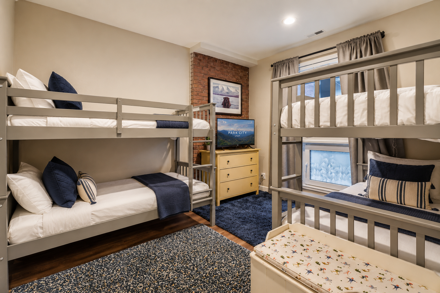 Cozy bunk room with exposed brick, perfect for families or groups. You'll love how the crisp white linens and navy accents create a restful retreat for everyone.