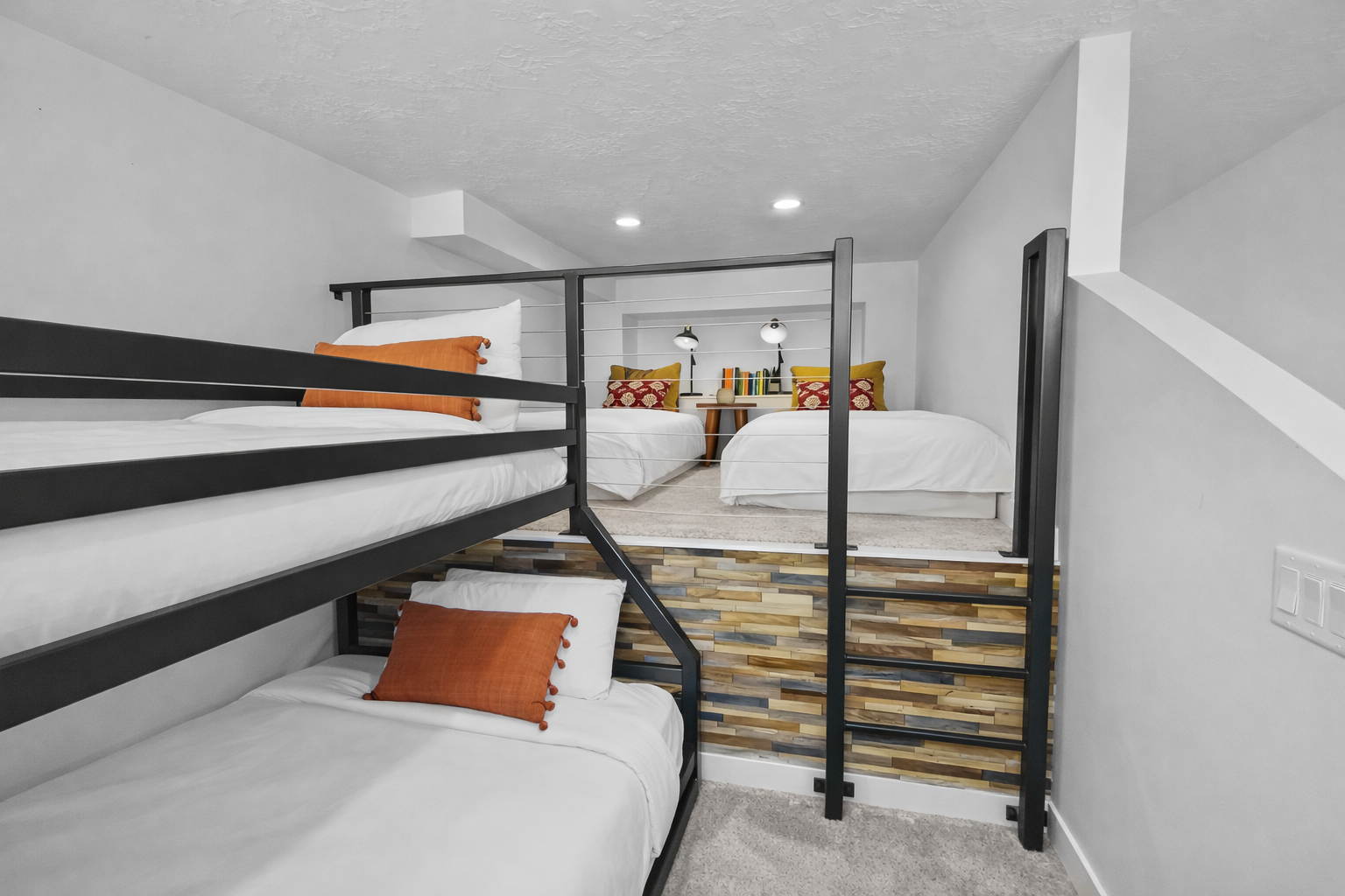 Your cozy sleeping space features modern bunk beds with plush bedding and warm orange accents for restful nights.