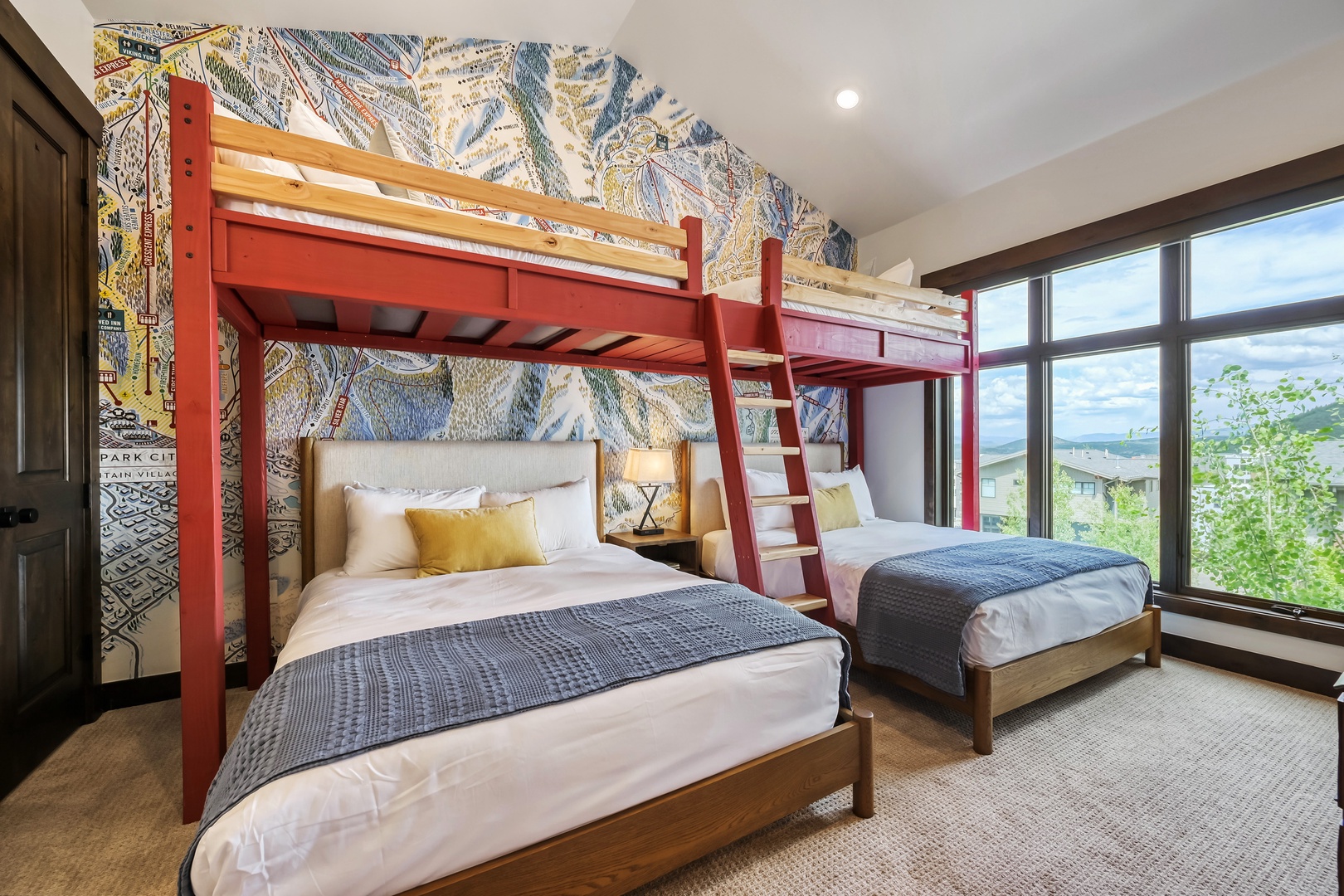 Your stylish mountain retreat awaits with inviting beds dressed in plush linens and a cheerful bunk above. Wake up to tree-lined views framed by floor-to-ceiling windows.