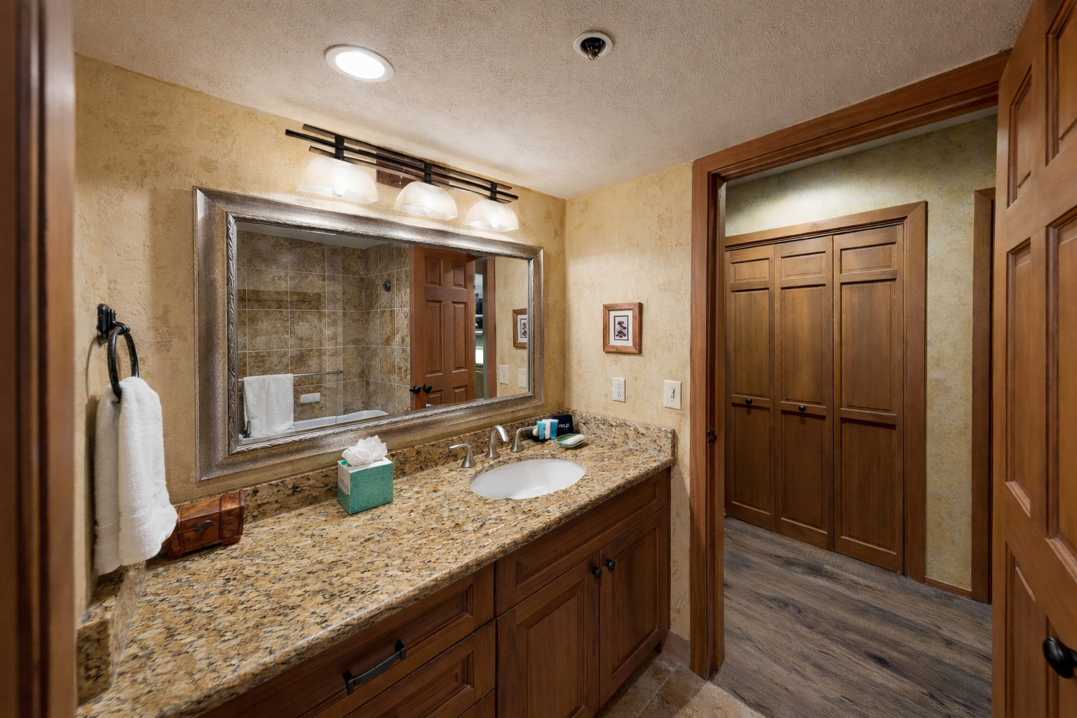 Unwind in your elegant bathroom featuring granite counters, rich wood cabinetry, and a soothing tub-shower combo for relaxing after your adventures.