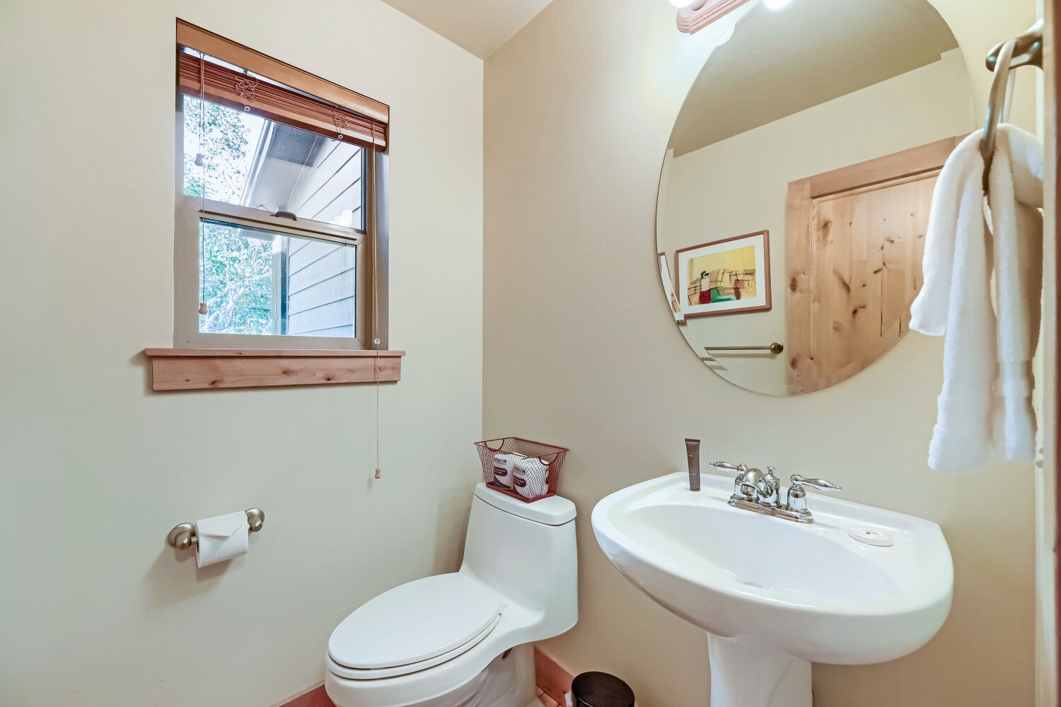 Freshen up in this light-filled bathroom with natural wood accents and everything you need for your comfort.