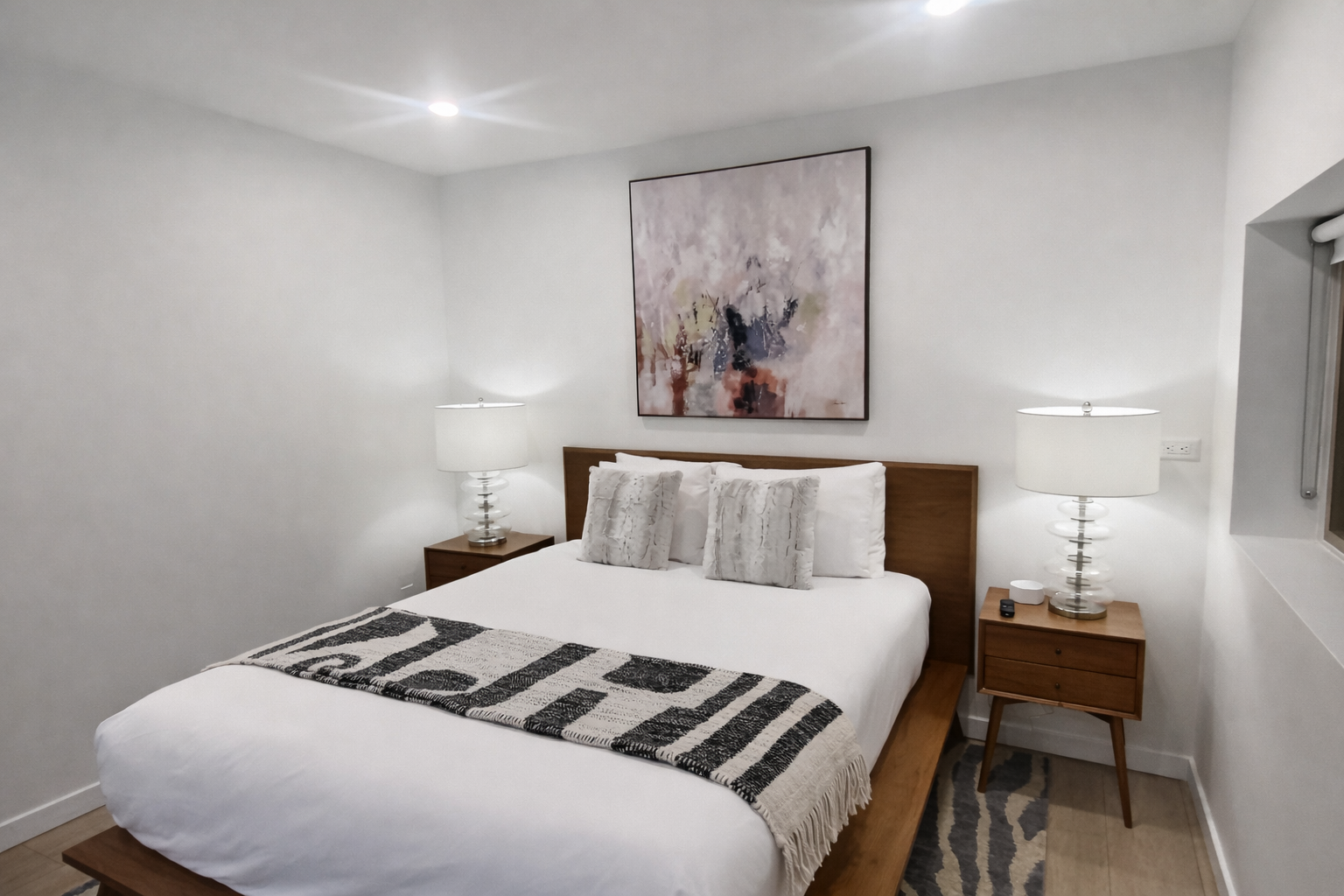 Relax in this serene, modern bedroom with a comfortable bed, ample storage, and a dedicated spin bike.