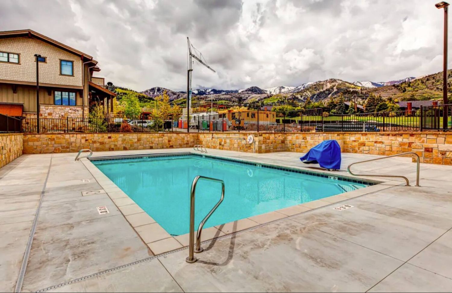 The property's outdoor pool offers a serene spot to unwind beneath dramatic mountain peaks and open skies.