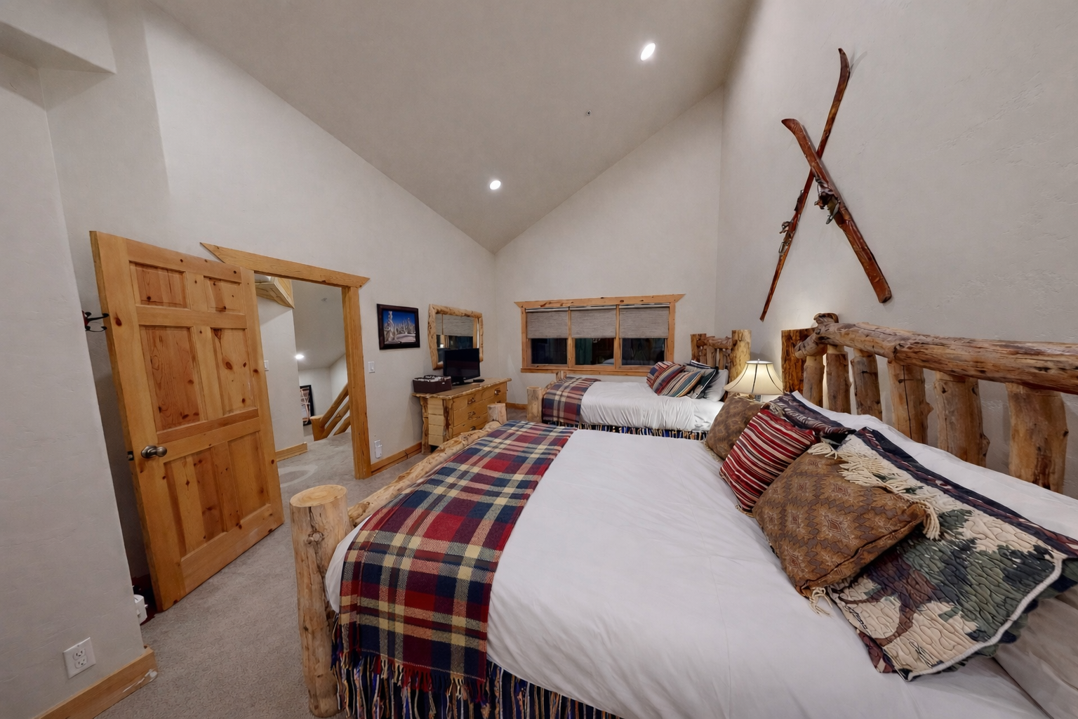 Step into your cozy mountain retreat where rustic log beds and plaid linens create the perfect alpine sanctuary for restful nights.