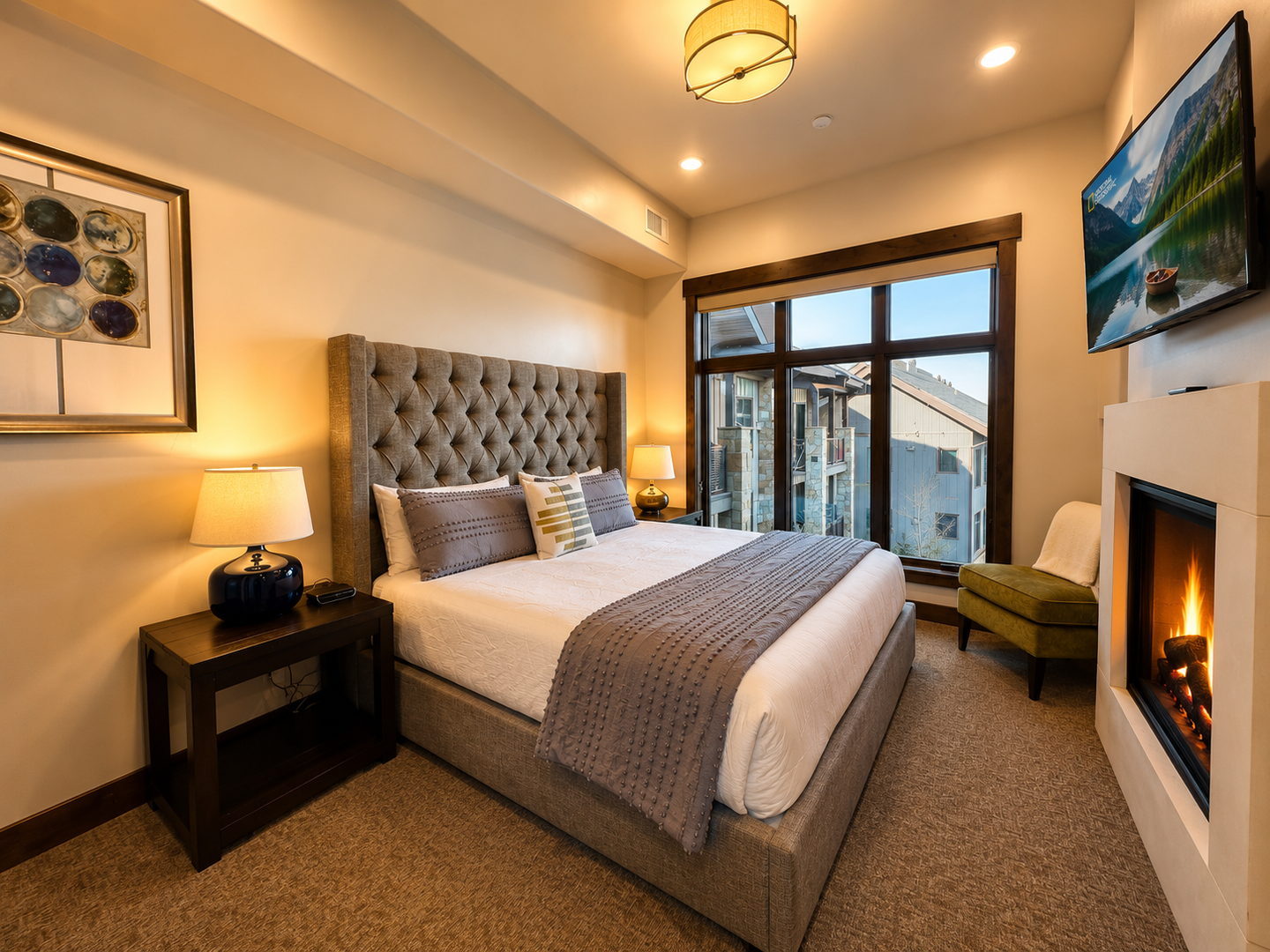 Unwind in this serene primary suite at Blackstone Overlook. This cozy retreat features a private gas fireplace, a wall-mounted Smart TV, and an ensuite bathroom, offering ultimate comfort after a day on the slopes.