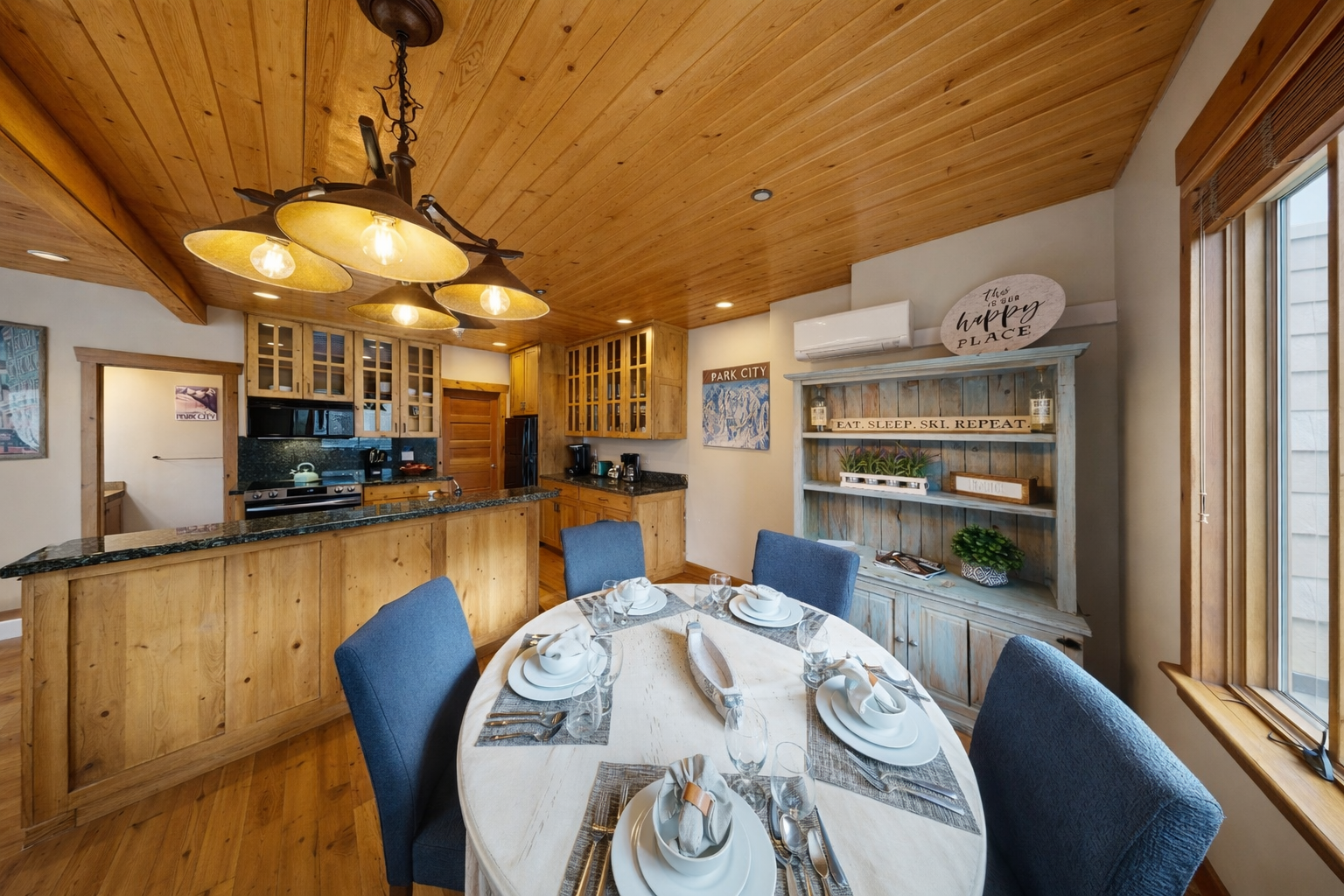Gather for memorable meals around the cozy dining table beneath the rustic wagon wheel chandelier. The fully equipped kitchen is steps away.