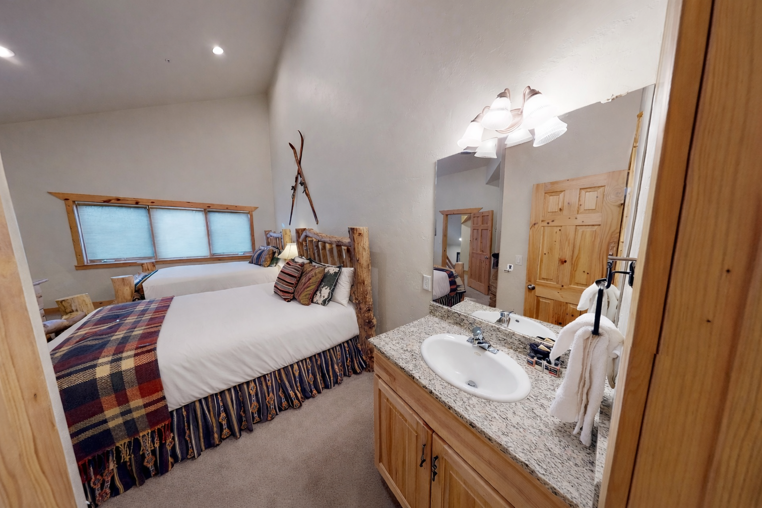 Unwind in your cozy bedroom featuring rustic wood details and plaid accents, with a convenient vanity area for your morning routine.