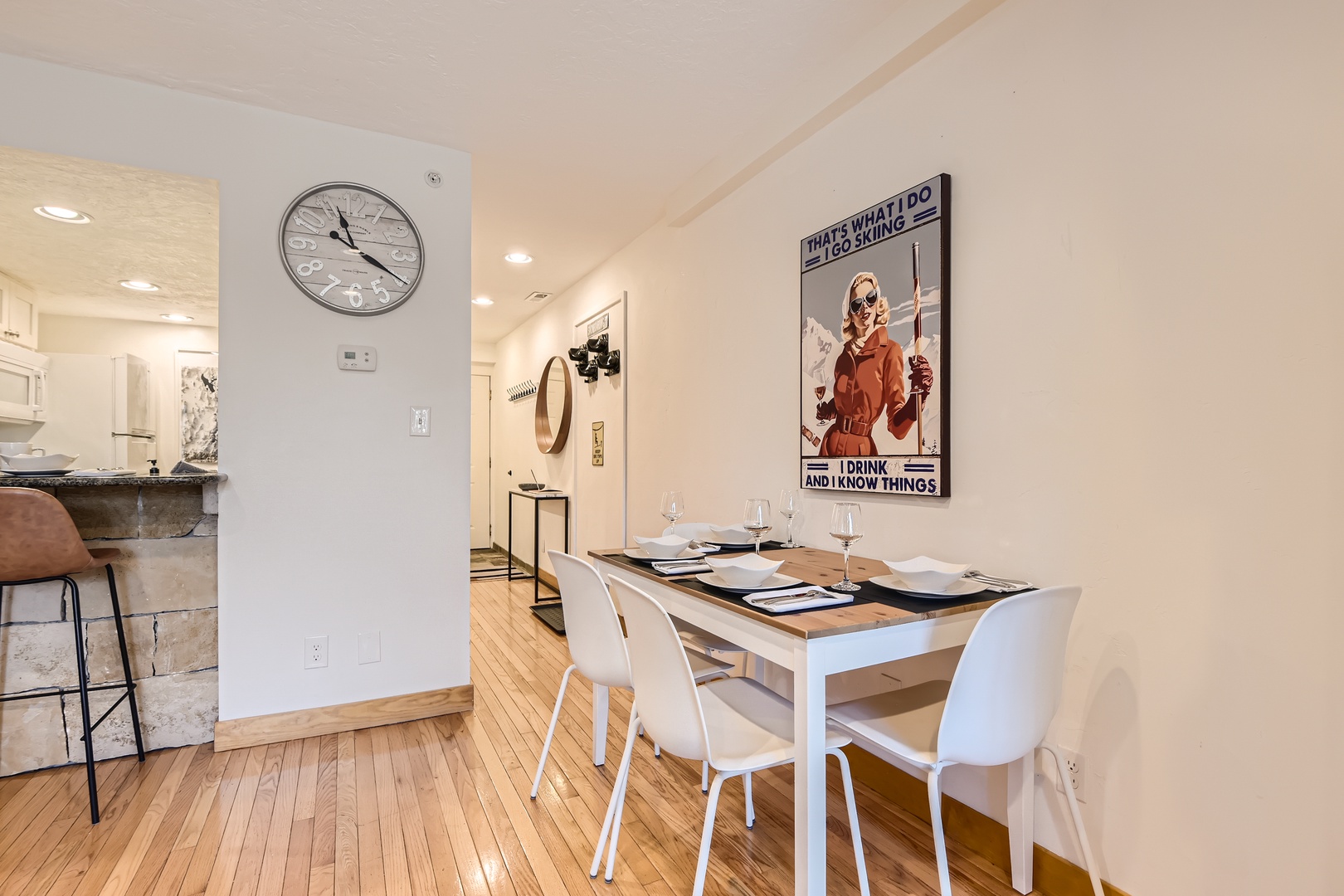 Gather around this inviting dining table, perfectly set for your meals and conversations. The open layout flows seamlessly into the kitchen, creating a warm, connected space for your group.