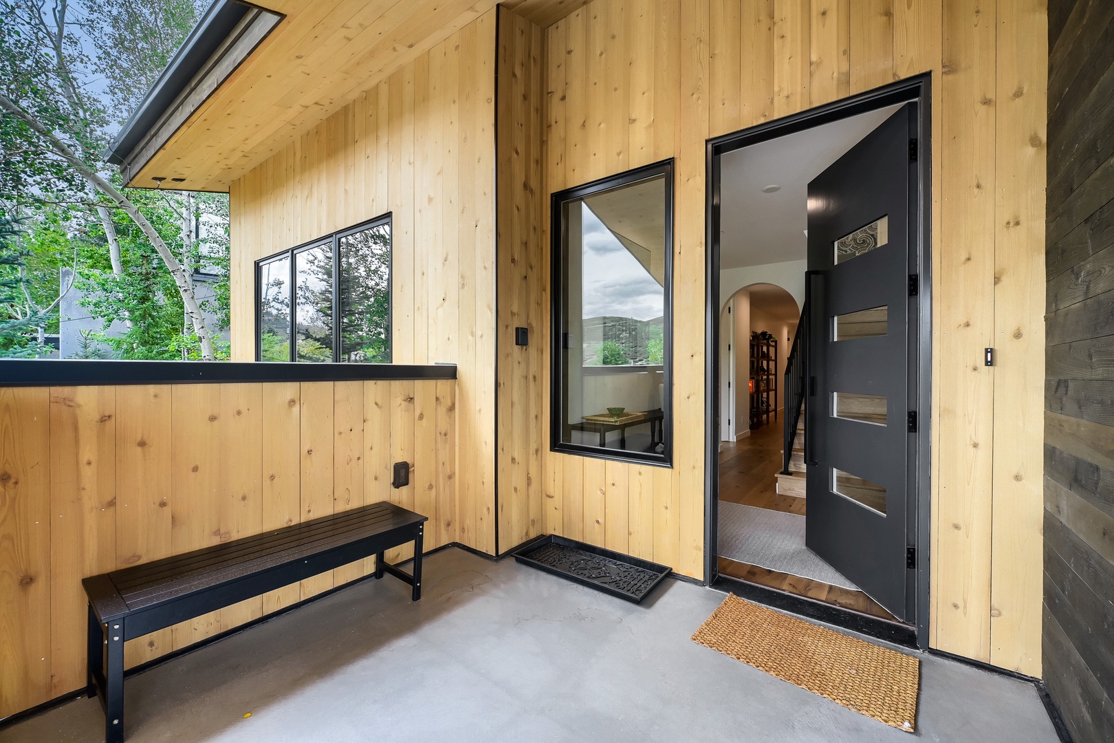 Welcome to your mountain retreat. Step onto the covered entrance where natural wood tones, fresh air, and nearby trails set the tone for your getaway.