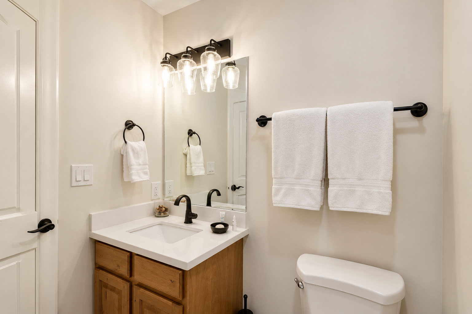 Refresh in your stylish bathroom with plush white towels, modern fixtures, and warm lighting creating a welcoming space for your morning routine.