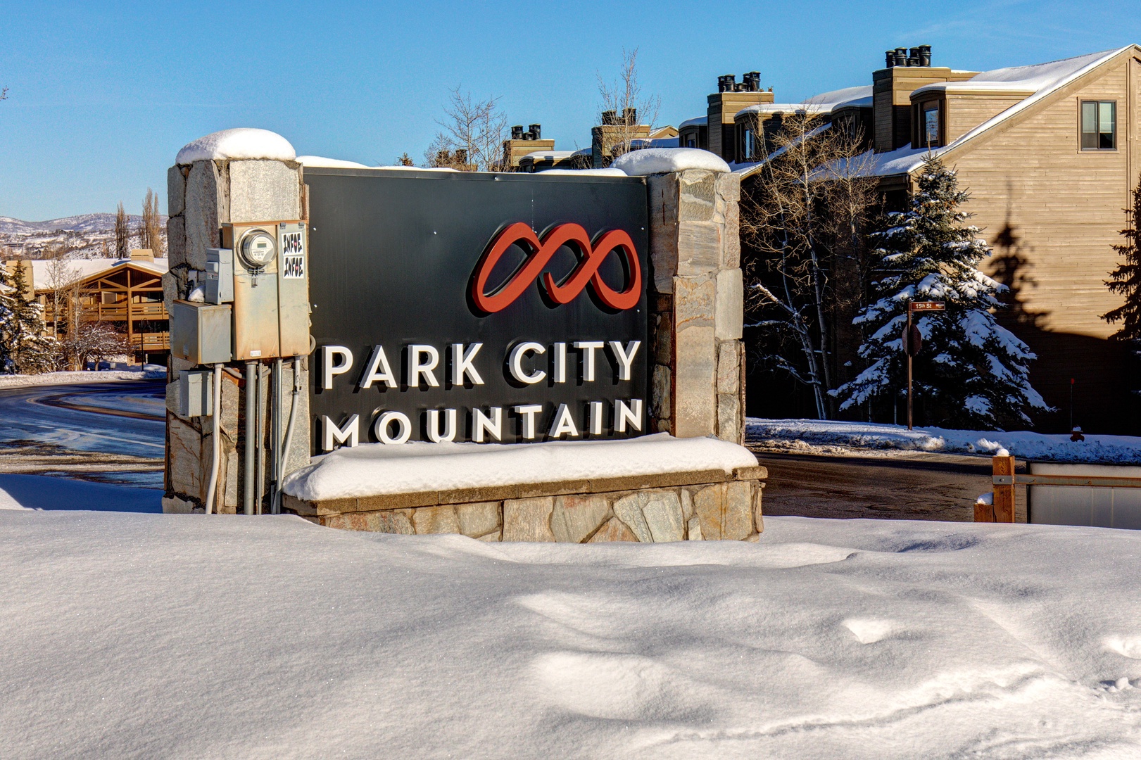 Park City Mountain entrance sign welcomes visitors to this premier ski destination amid snow-covered surroundings.