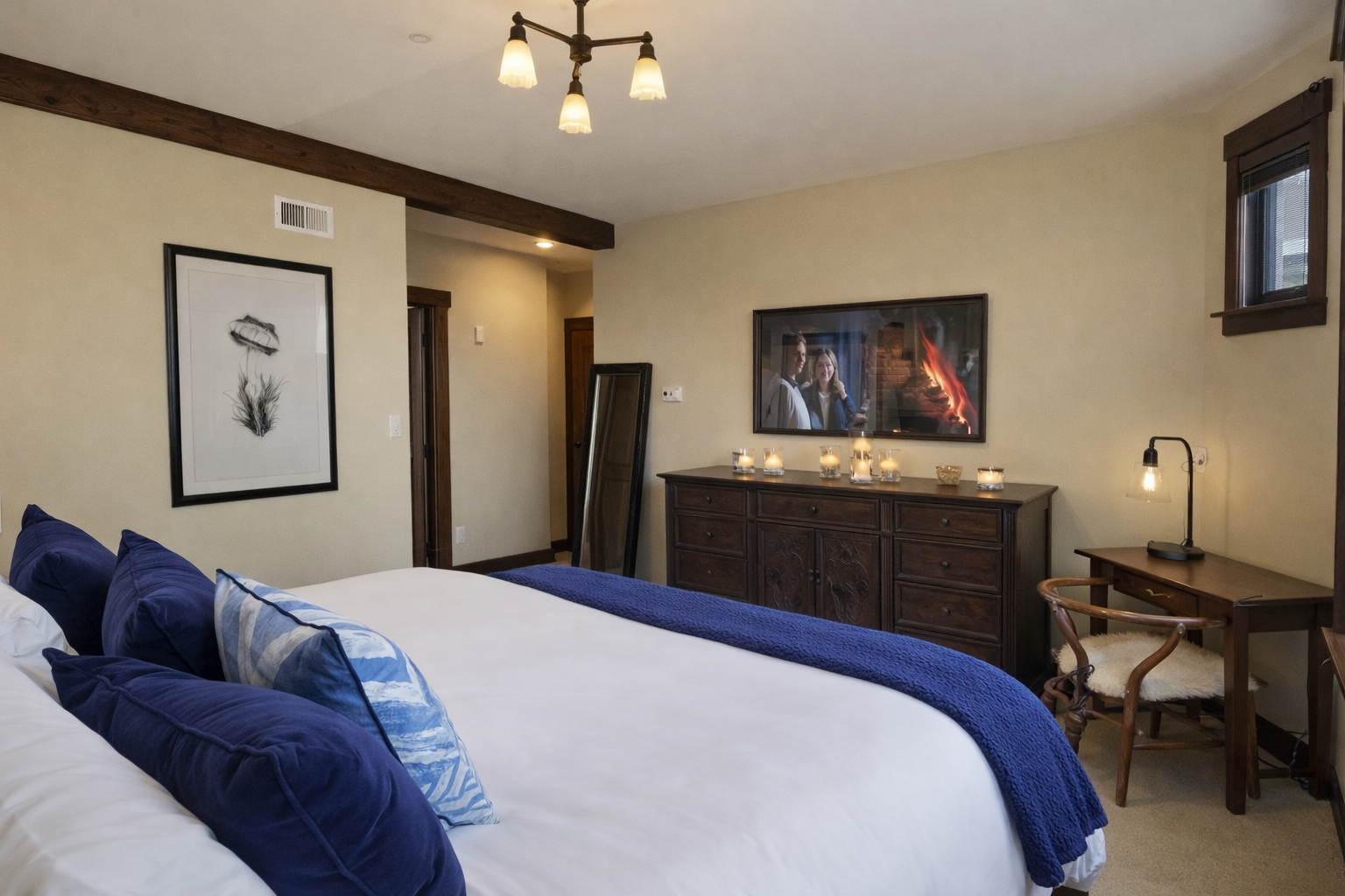 Sink into this cozy bedroom's plush king bed with navy accents while enjoying your favorite shows on the wall-mounted TV.