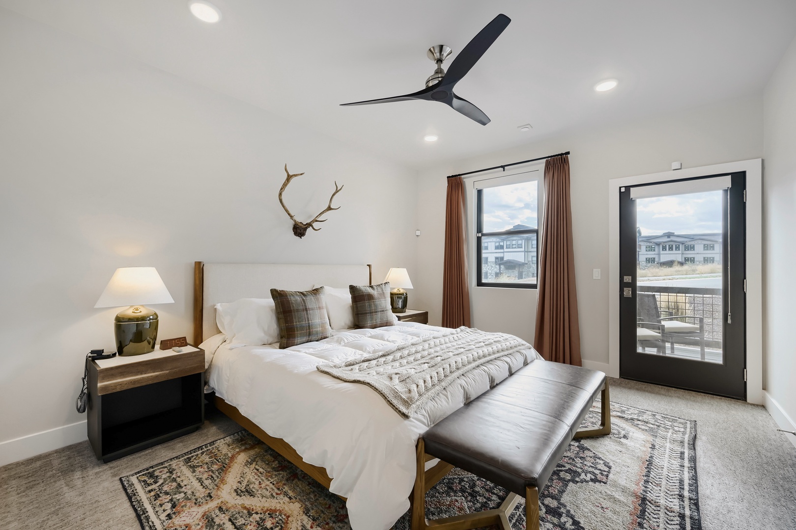 Retreat to your peaceful bedroom, where soft bedding, a sleek ceiling fan, and a scenic balcony invite complete relaxation after a day of exploring.