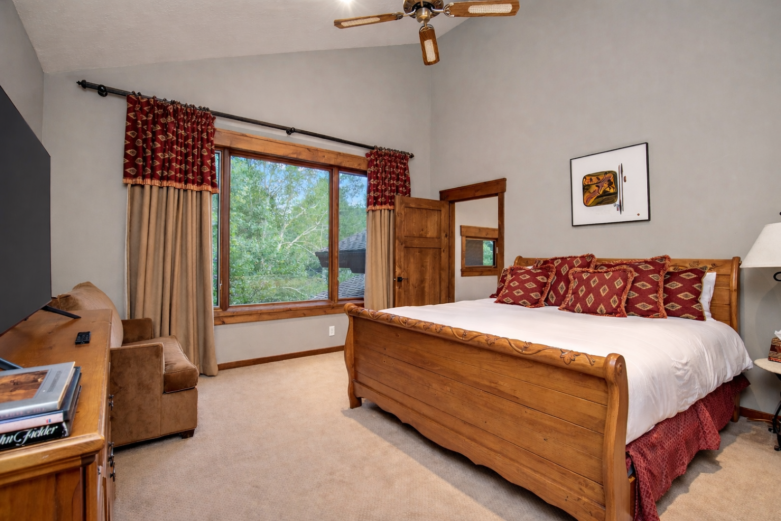 Unwind in your cozy bedroom featuring a beautiful log-style bed, warm wood accents, and peaceful forest views through the window.