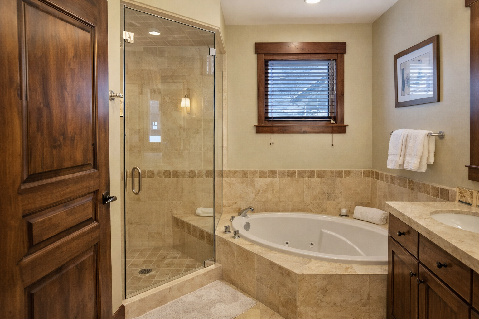 Unwind in your luxurious bathroom featuring a deep soaking tub and spacious glass shower with elegant stone finishes.