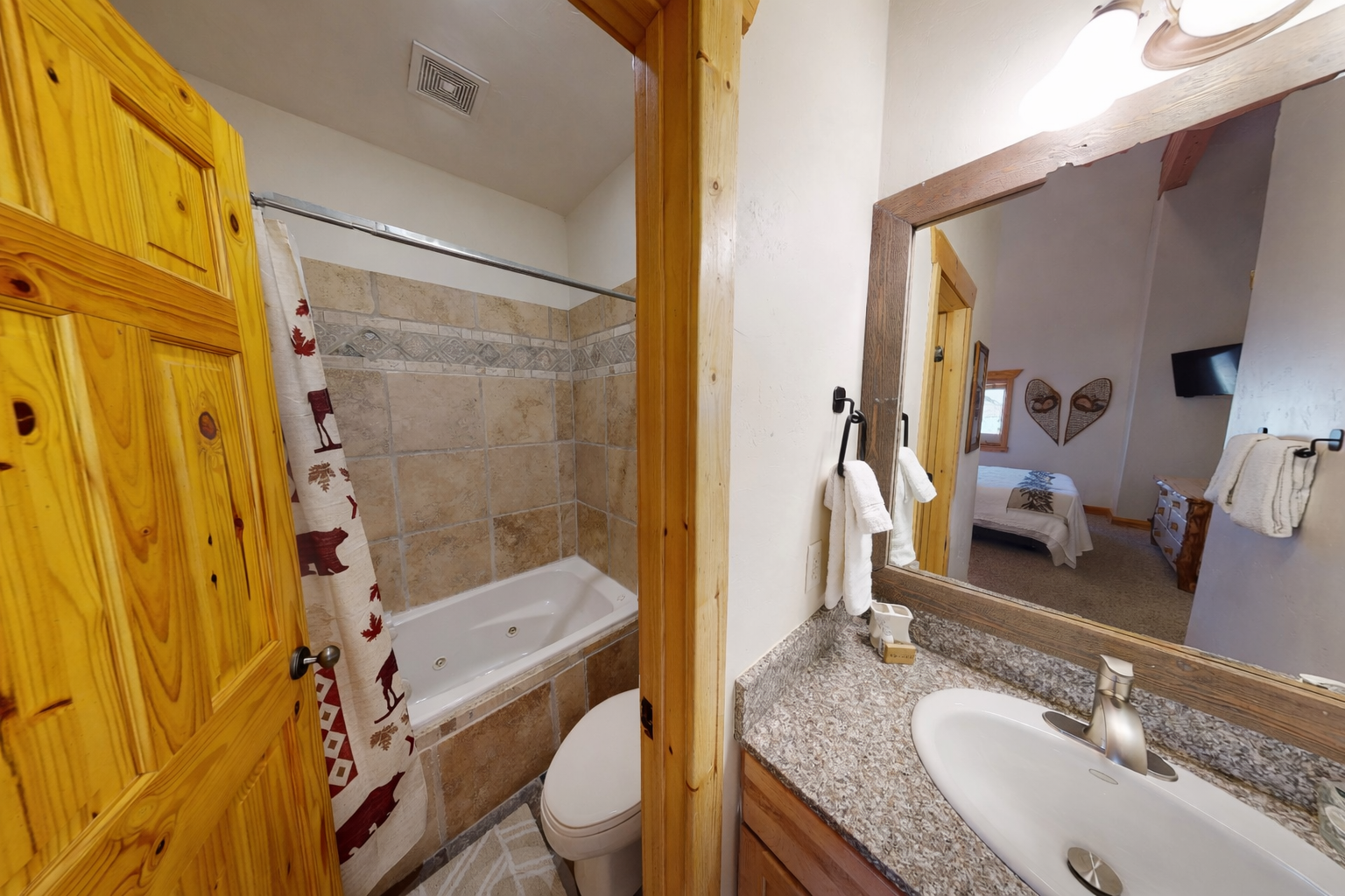 Your private bathroom features a jetted tub for soaking away the day's adventures, granite countertops, and rustic pine accents that add warmth and mountain charm to your retreat.