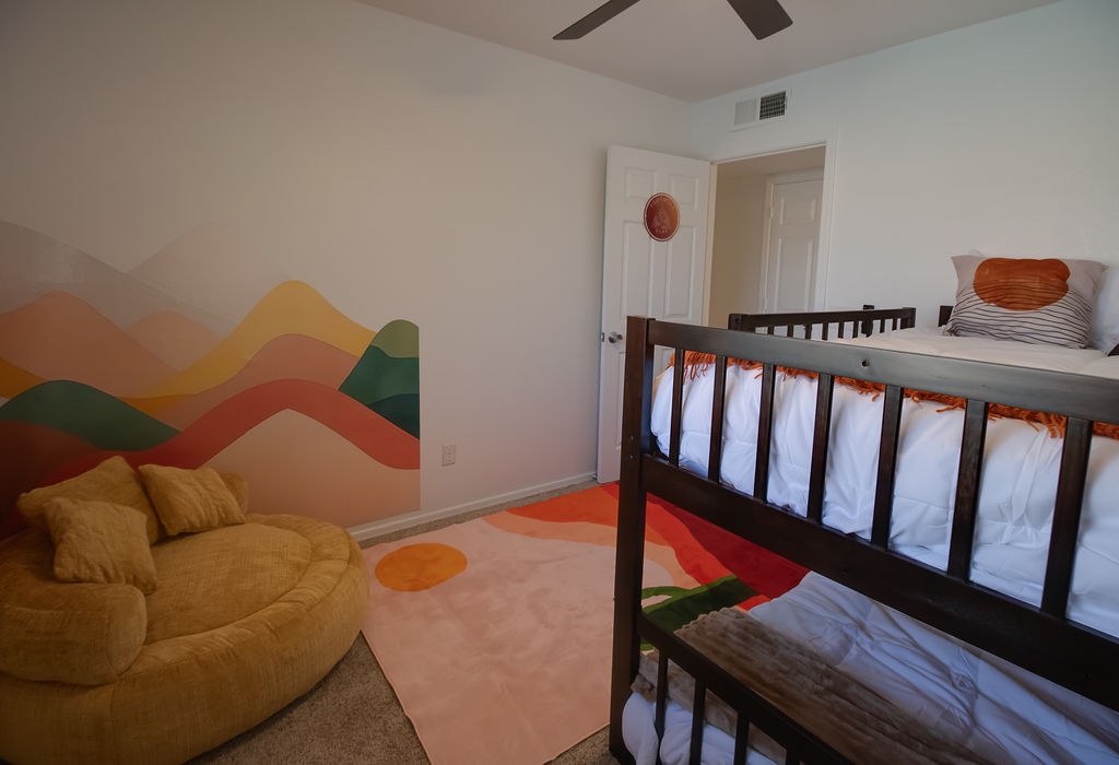Your kids will love this colorful mountain-themed room with bunk beds and cozy seating for bedtime stories.