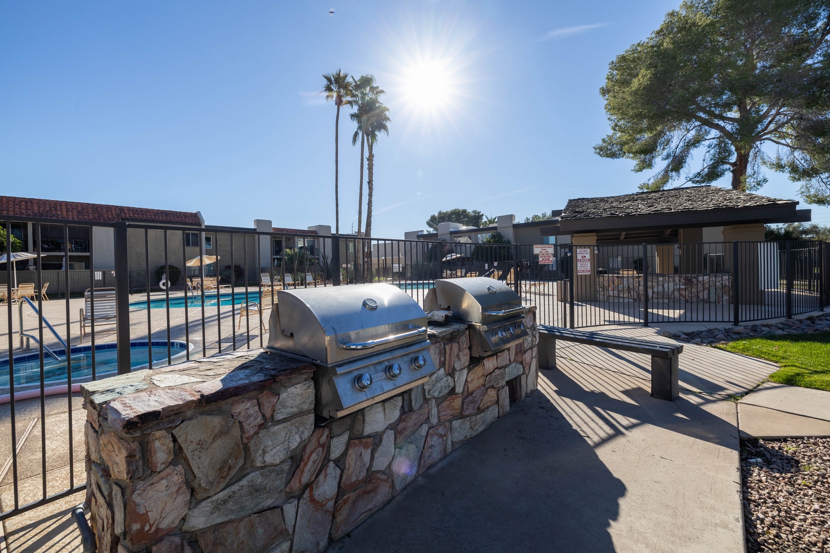 Community barbecue grill by the pool area.