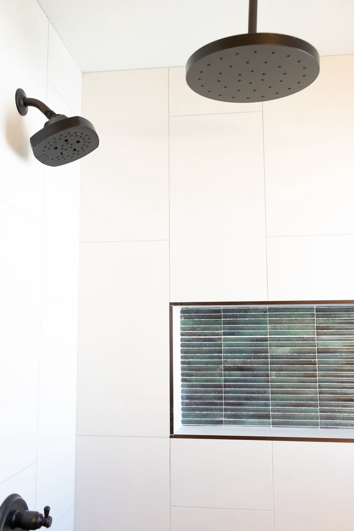 Step into your spa-like shower featuring dual rainfall heads and elegant tile accents for the ultimate relaxing experience.