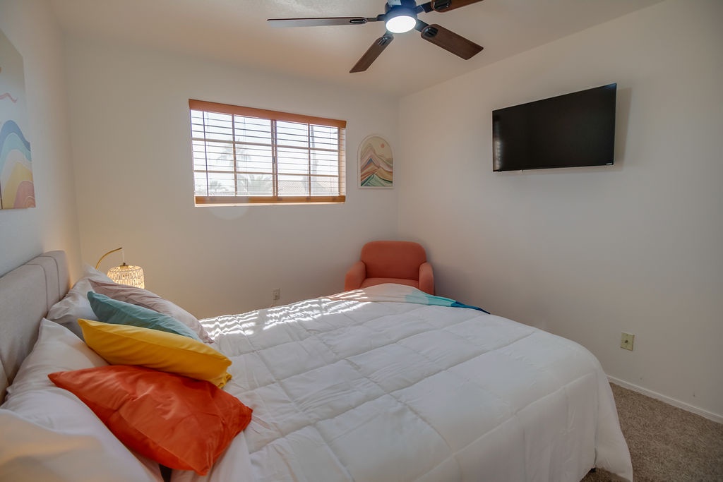 Sink into crisp white bedding with cheerful pillows while your ceiling fan keeps you cool and comfortable.