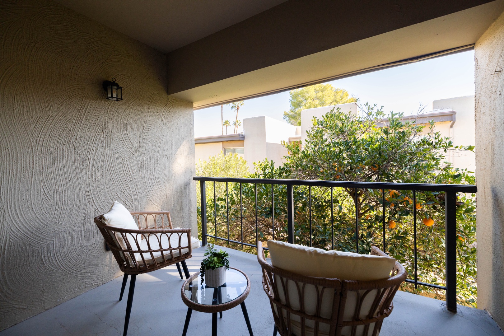 Unwind on your private covered balcony overlooking leafy citrus trees.