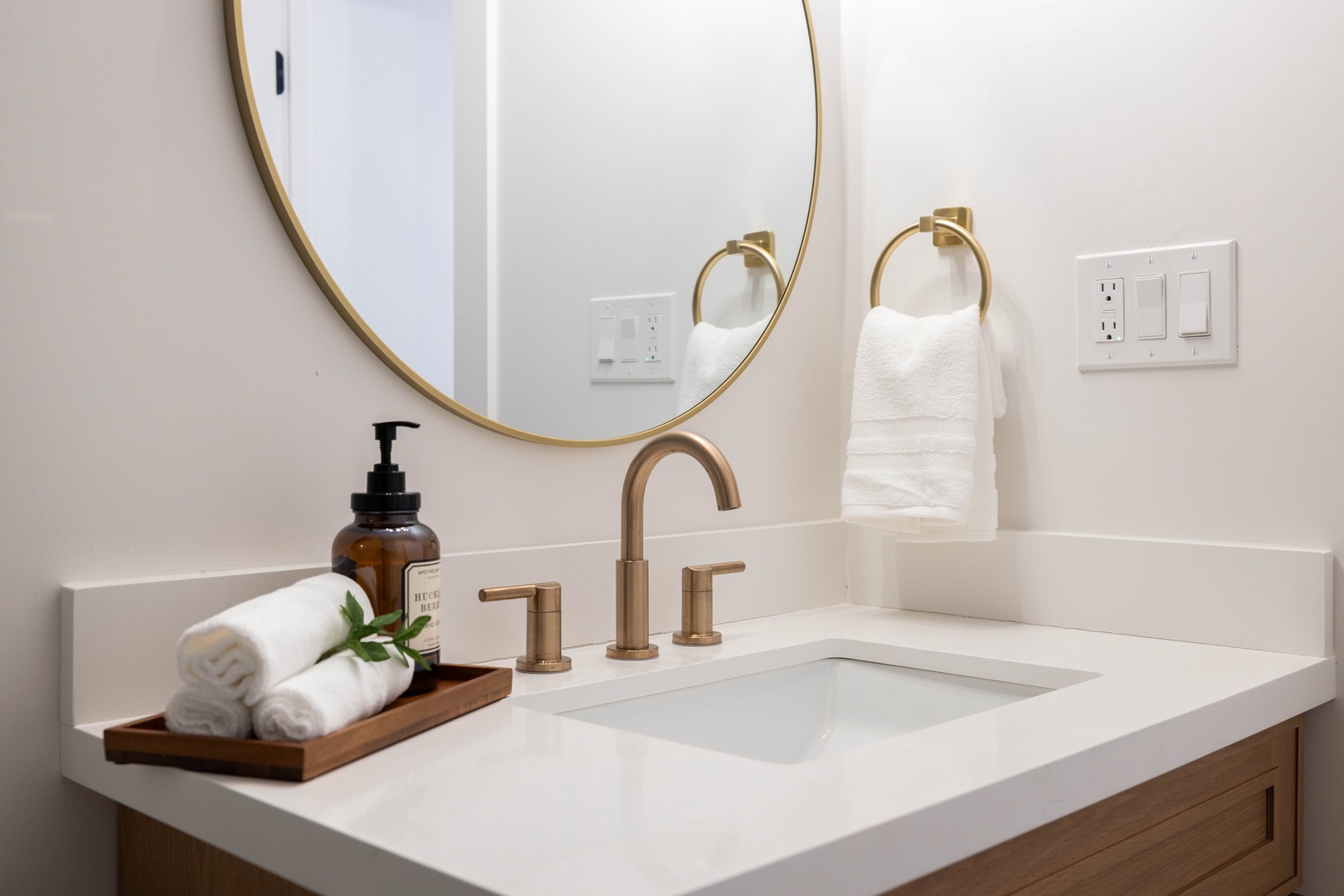 Refresh in this elegantly designed bathroom featuring brass fixtures, marble countertops, and thoughtful amenities for your comfort.