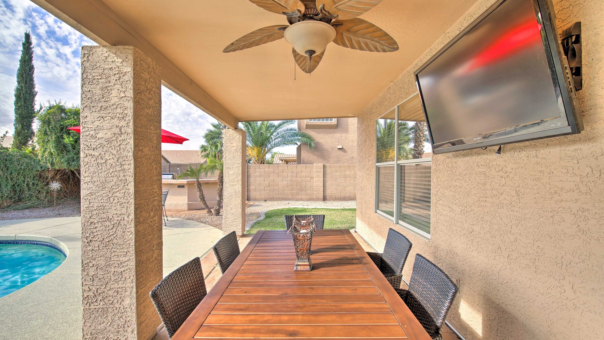 Your covered patio dining space features a beautiful wooden table for outdoor meals