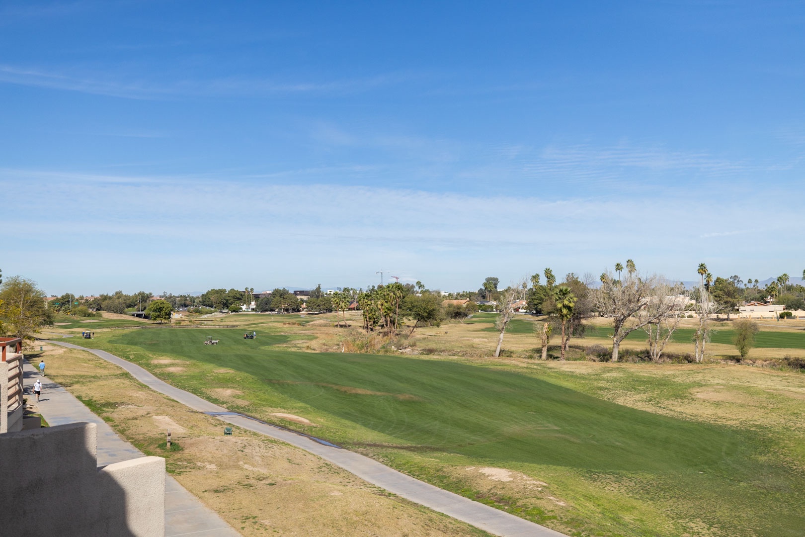 Championship golf course with scenic fairways and palm trees visible from the property balcony.