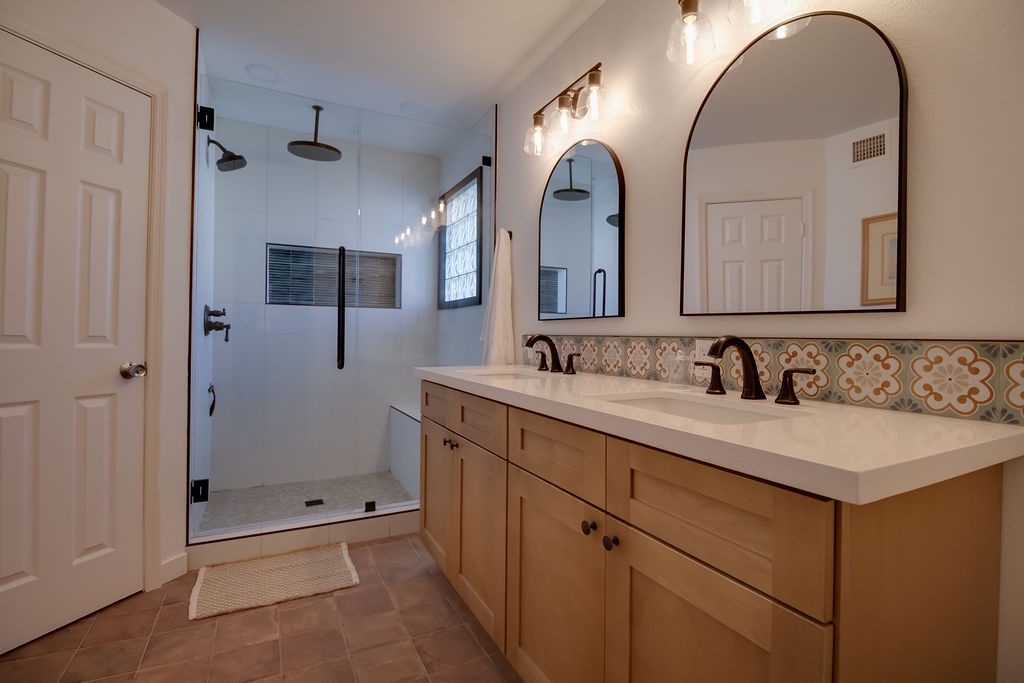 Refresh in your spacious bathroom featuring elegant marble counters, dual sinks, and a stunning walk-in shower with rainfall head.