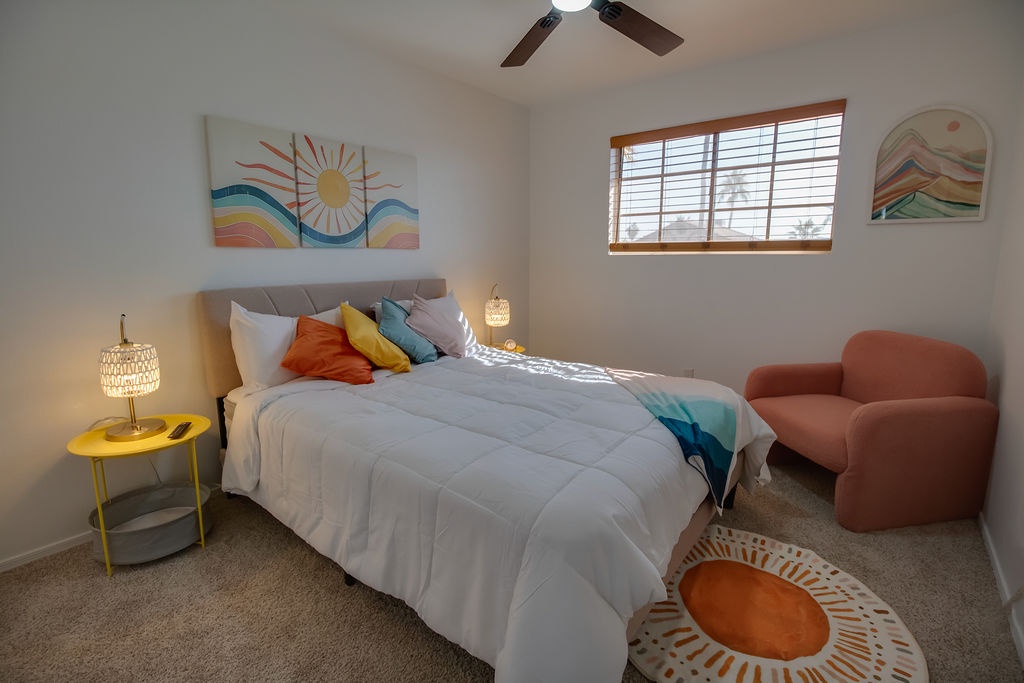 Your bright bedroom features colorful artwork, soft linens, and a cozy reading chair where you can unwind after exploring.