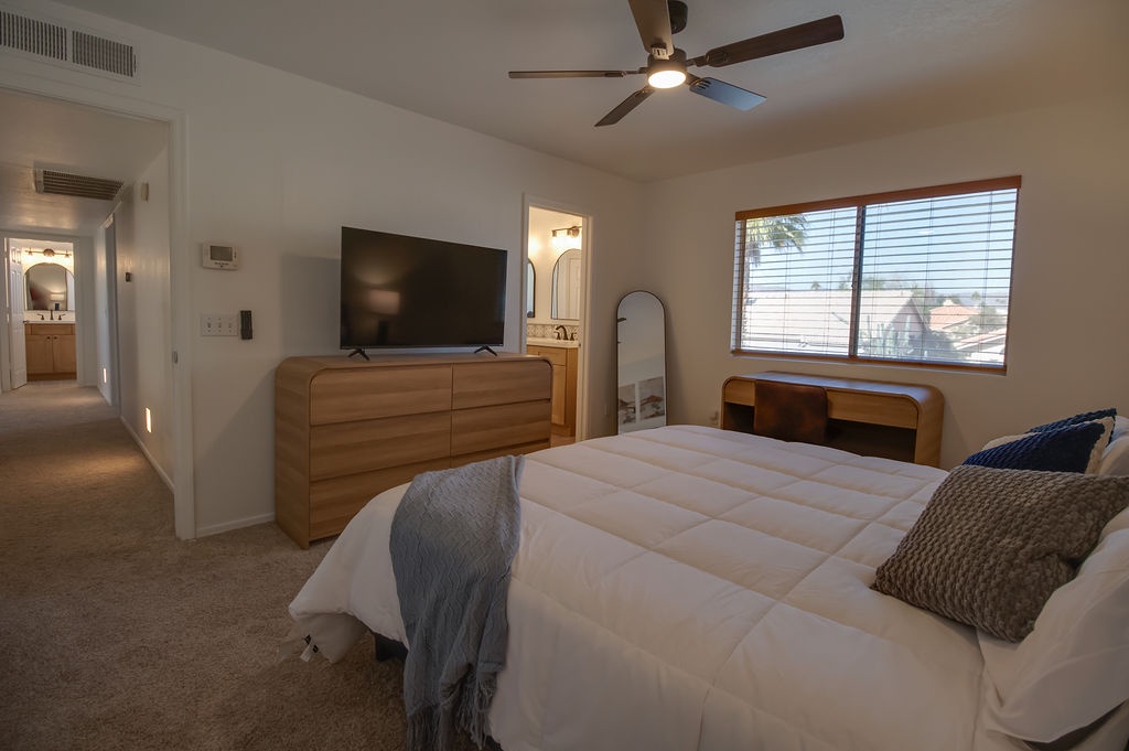 Unwind in your spacious bedroom with plush bedding, smart TV entertainment, and warm wood accents creating the perfect retreat.