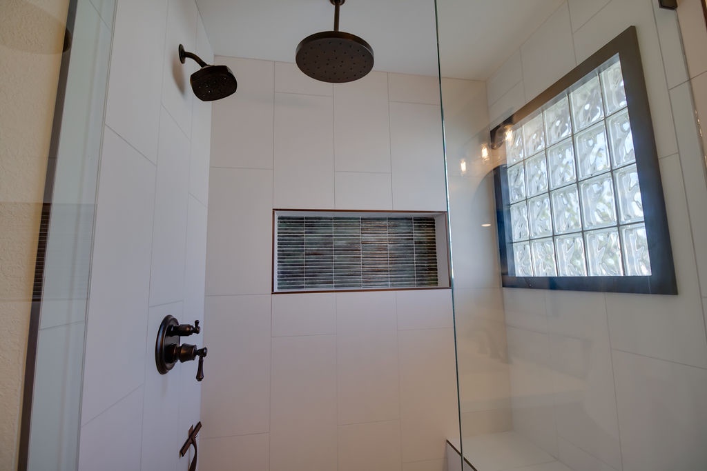Your spa-like shower features dual rainfall heads and elegant tile accents for the perfect start to your day.