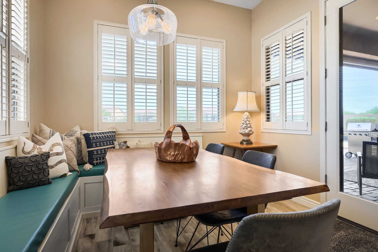 Gather around the handcrafted wooden table for meals bathed in natural light, with cozy bench seating and a private door leading to your outdoor space.