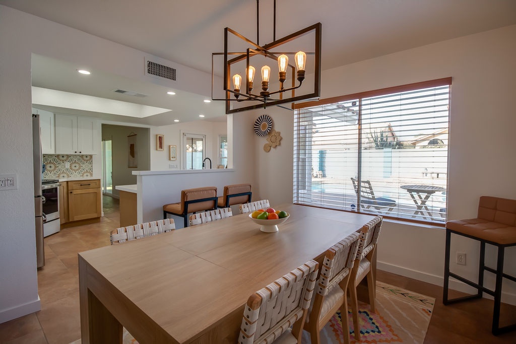 Gather around your spacious dining table where warm pendant lighting creates the perfect ambiance for memorable meals with loved ones.