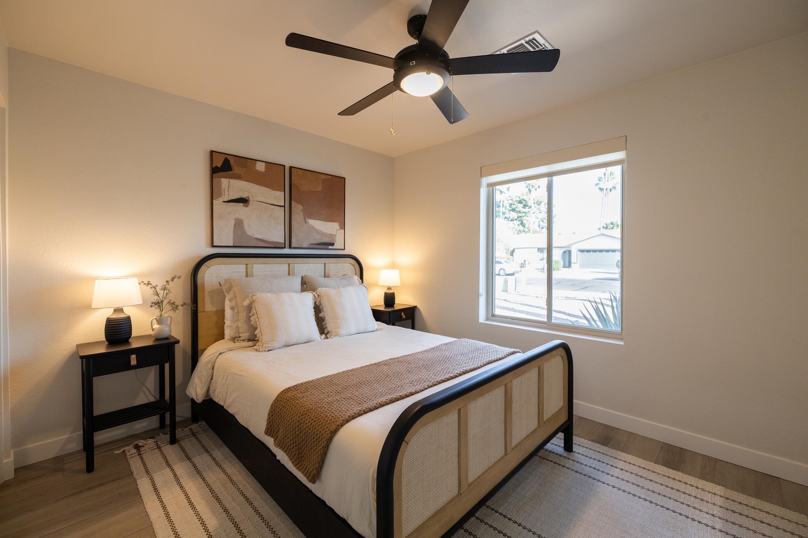 Stylish queen guest room with warm lighting & Southwest vibes