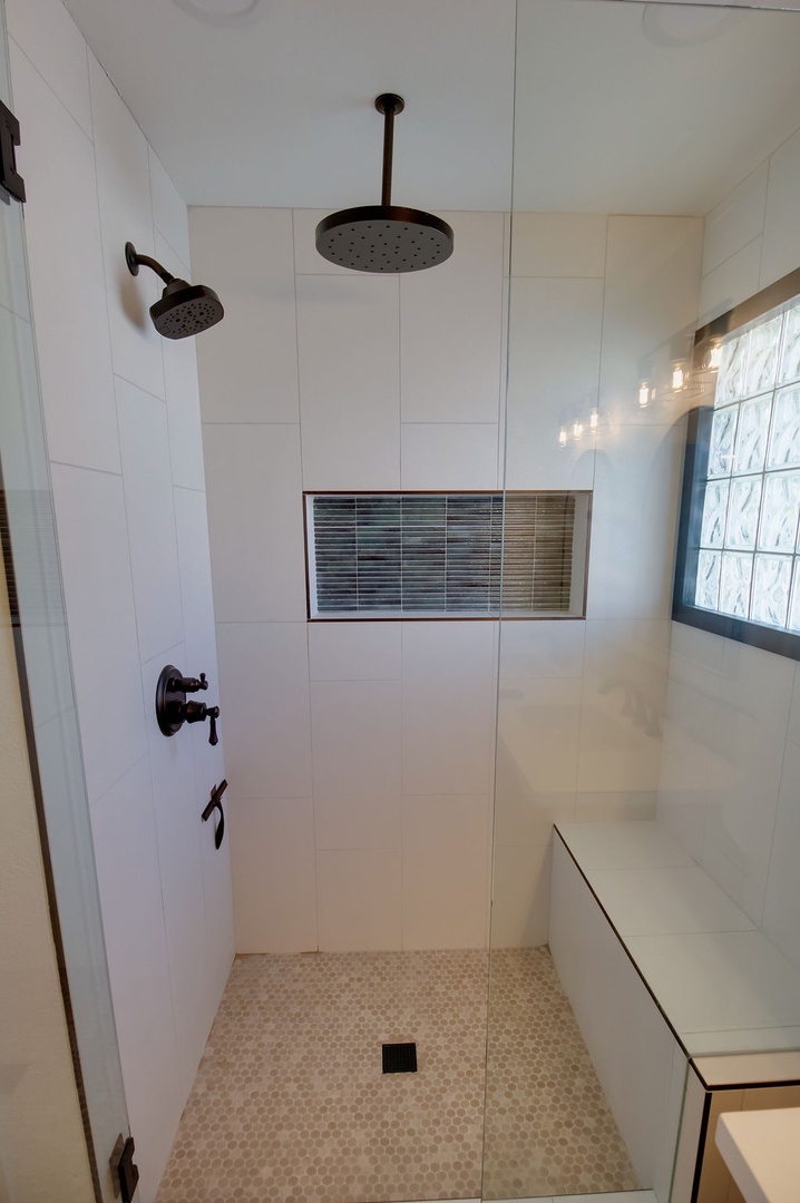 Step into your private spa-like shower with dual rainfall heads and elegant mosaic details for the ultimate relaxation.