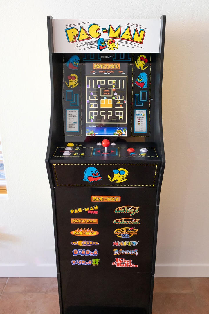 Challenge your friends to classic arcade battles on this nostalgic Pac-Man machine, featuring multiple retro games for endless entertainment.