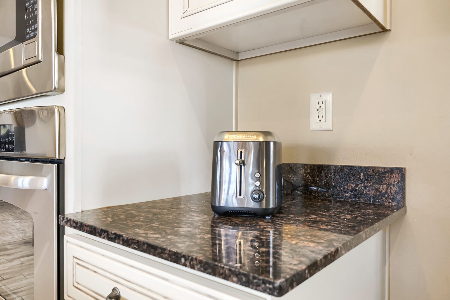 Your kitchen comes equipped with modern stainless steel appliances and elegant granite countertops, with a convenient toaster ready for easy breakfasts.