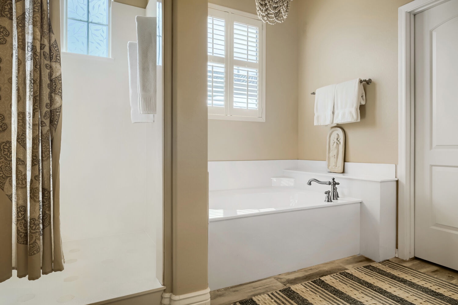 Step into your tranquil bathroom retreat, where soft natural light filters through plantation shutters and a deep soaking tub awaits your relaxation. Fresh white linens and elegant details create a spa-like sanctuary.