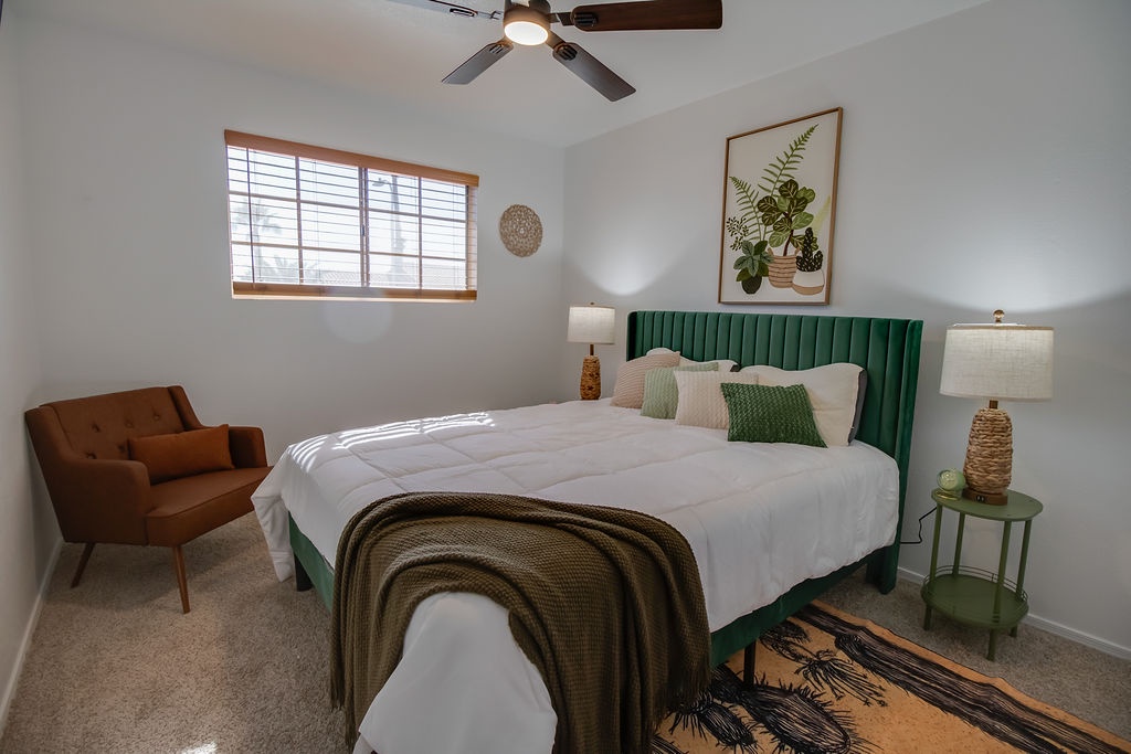 Sink into comfort in this stylish bedroom where the emerald headboard and cozy reading chair create your perfect retreat for rest and relaxation.