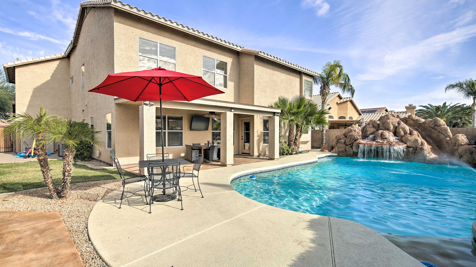 A beautiful two-story vacation home featuring a stunning private pool with rock waterfall