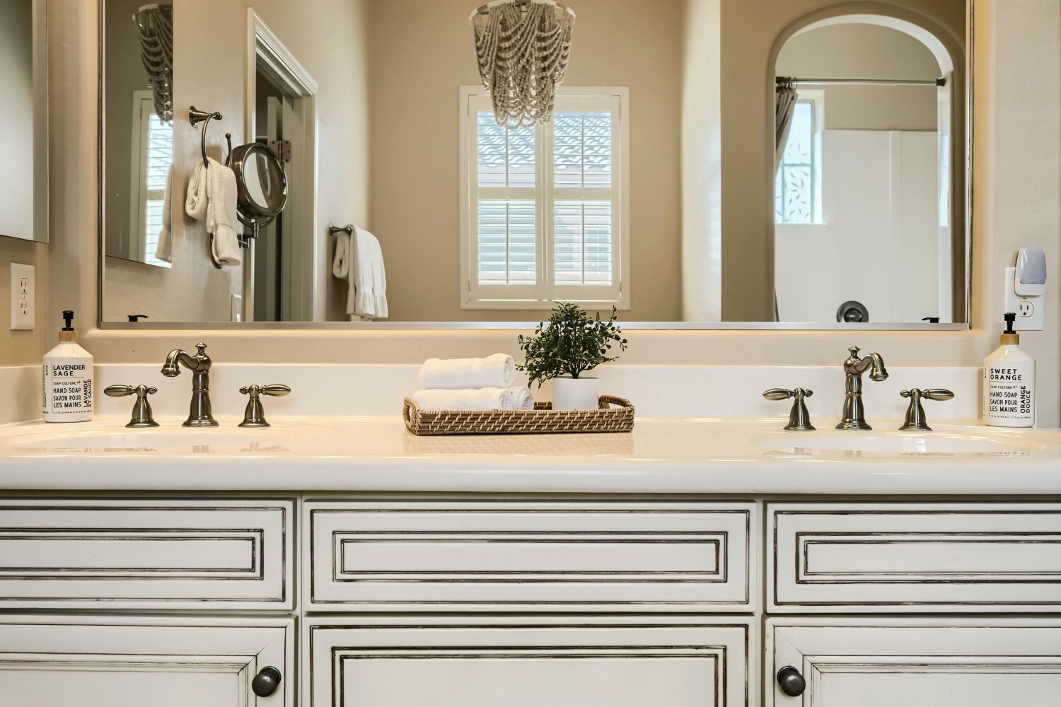 Indulge in this elegant dual-vanity bathroom with soft natural light, plush towels, and thoughtful touches. Your mornings begin with calm sophistication and all the space you need.