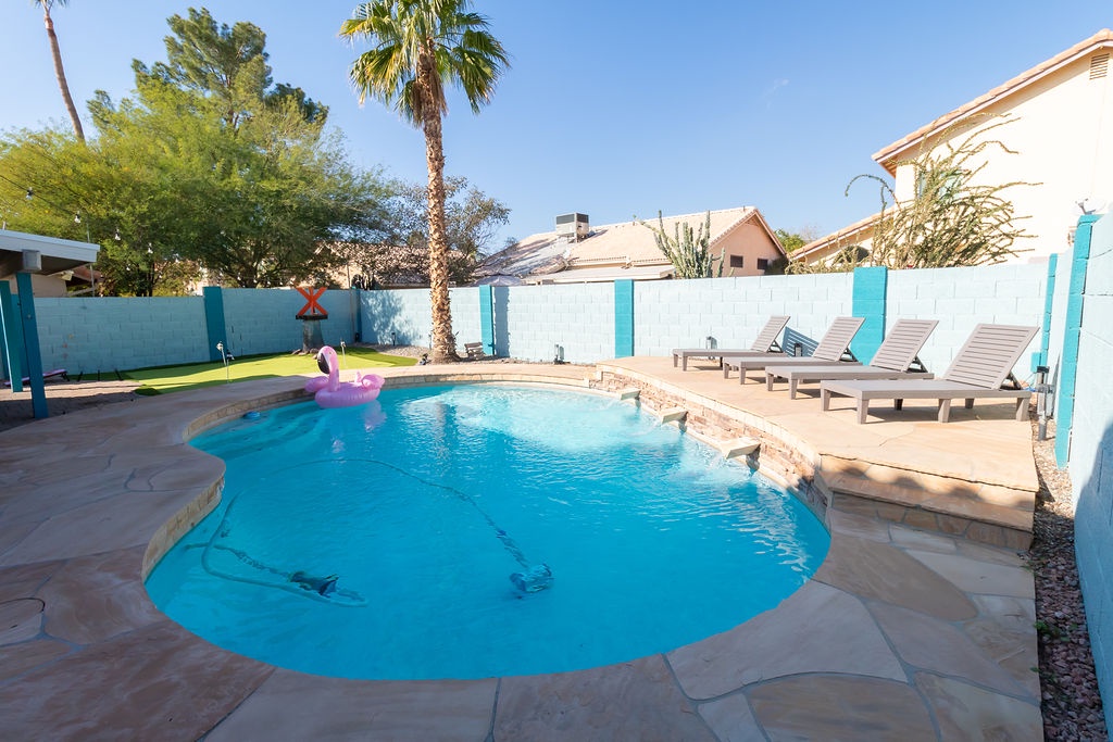 Dive into your private oasis with this sparkling pool surrounded by comfortable loungers, perfect for soaking up the desert sun.