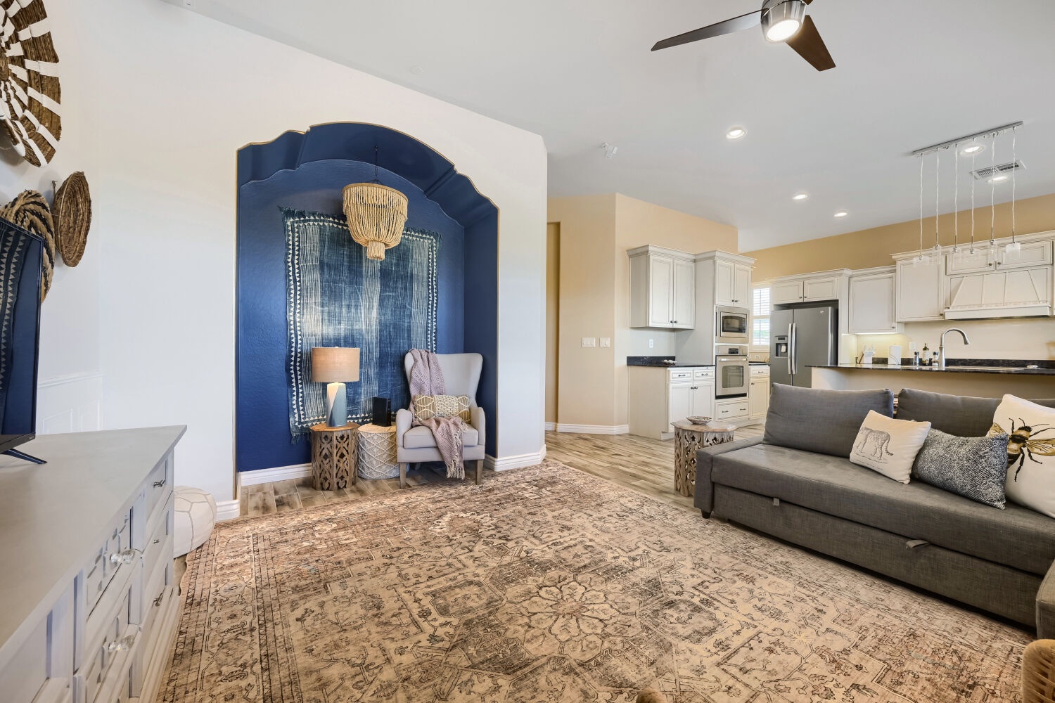 Settle into your spacious living area, where a cozy alcove with plush seating invites you to unwind. The open layout flows seamlessly into a bright, fully-equipped kitchen—perfect for making yourself at home.